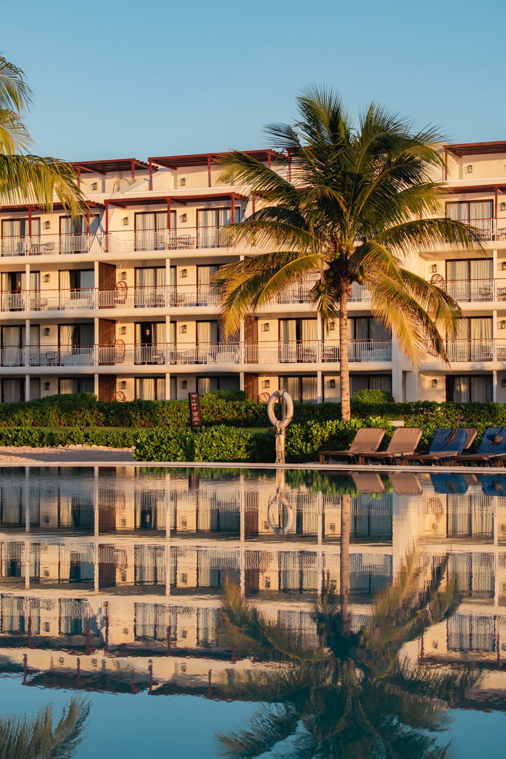 A beachside resort and swimming pool in warm golden-hour light